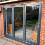 3 pane anthracite aluminium bi-fold with graphite furniture.