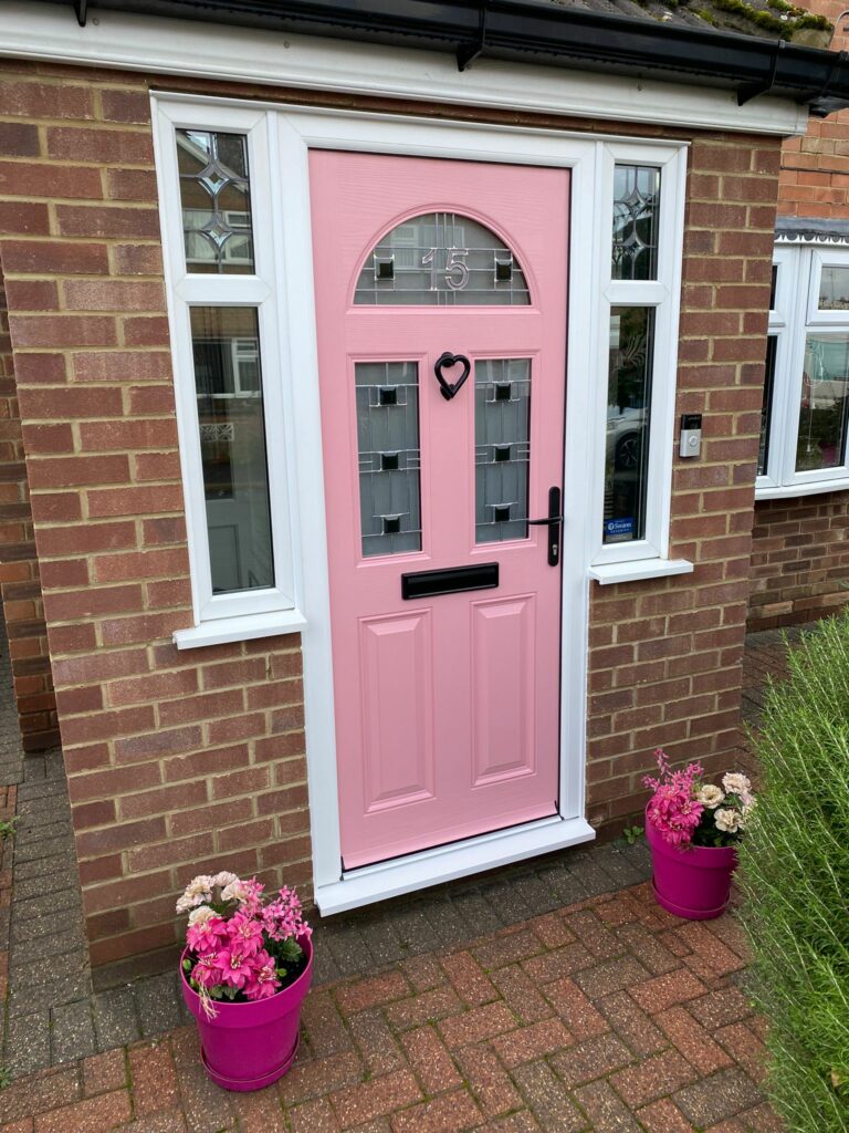 A lovely pink composite door with black features and aspen zinc glass.